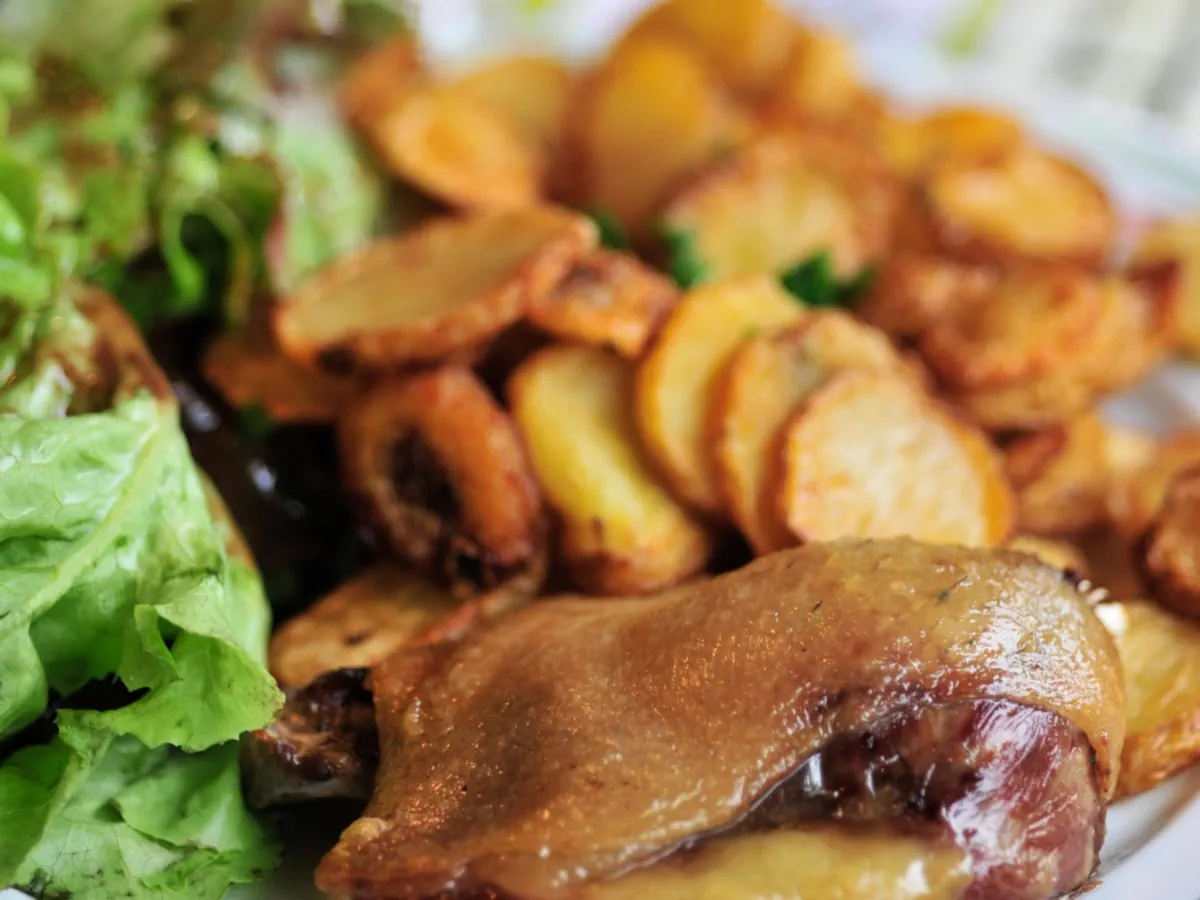 Assiette de confit de canard accompagnées de pommes sarladaises.